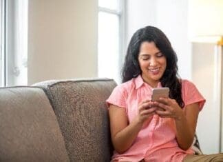 Panhandle 2-1-1 Helpline Adds Texting Option Hispanic Woman At Home Reading Her Text.