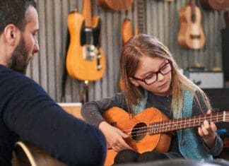 Why January Is the Perfect Time to Begin Music Lessons Dad,teaching,guitar,and,ukulele,to,his,daughter.little,girl,learning